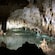 Clear subterranean cave water with stalactites and stalagmites